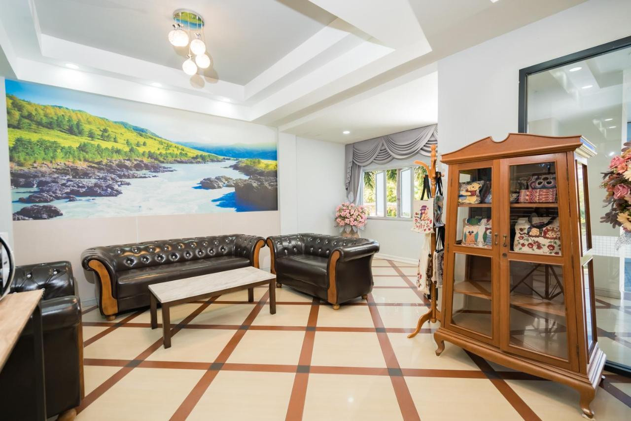 Top Inn Hotel Maha Sarakham lobby with leather sofas, wooden cabinet and a riverside mural