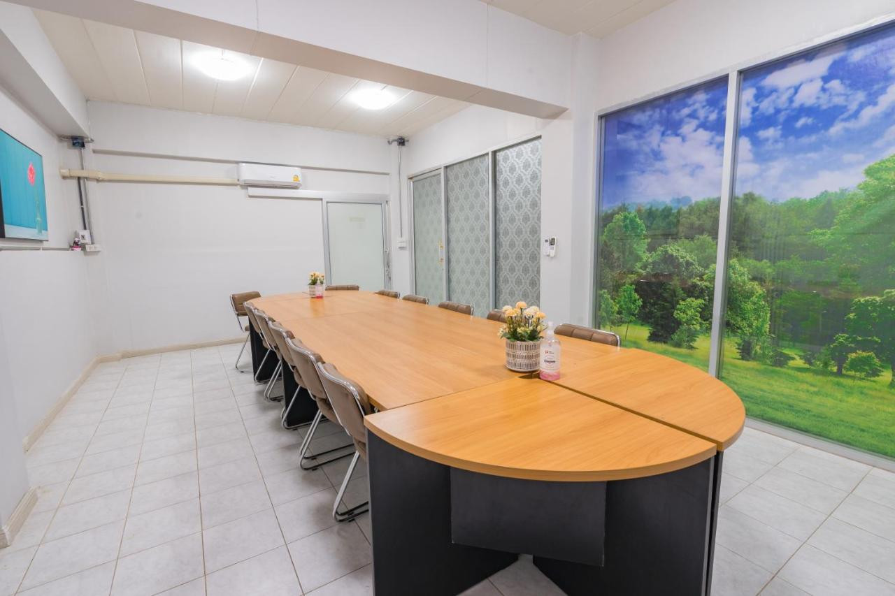 Meeting room with a large wooden table at Top Inn Hotel with a decorative nature mural along the back wall