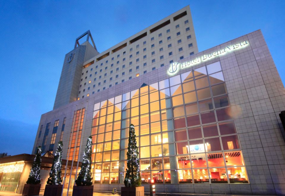 Hotel Buena Vista Matsumoto exterior facade at dusk with illuminated signage and glass-curtain tower