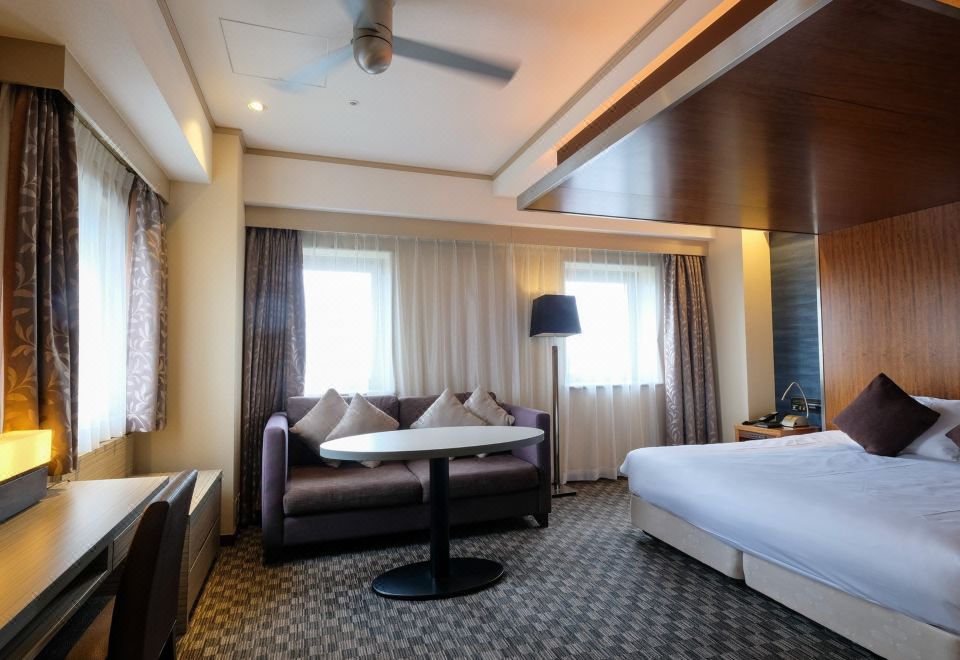 Deluxe double room at Hotel Buena Vista Matsumoto with sofa seating area and large bed