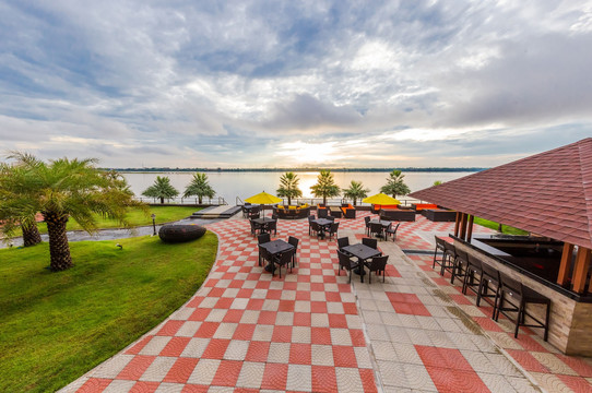 Mekong riverfront terrace with tables facing the sunset over Laos