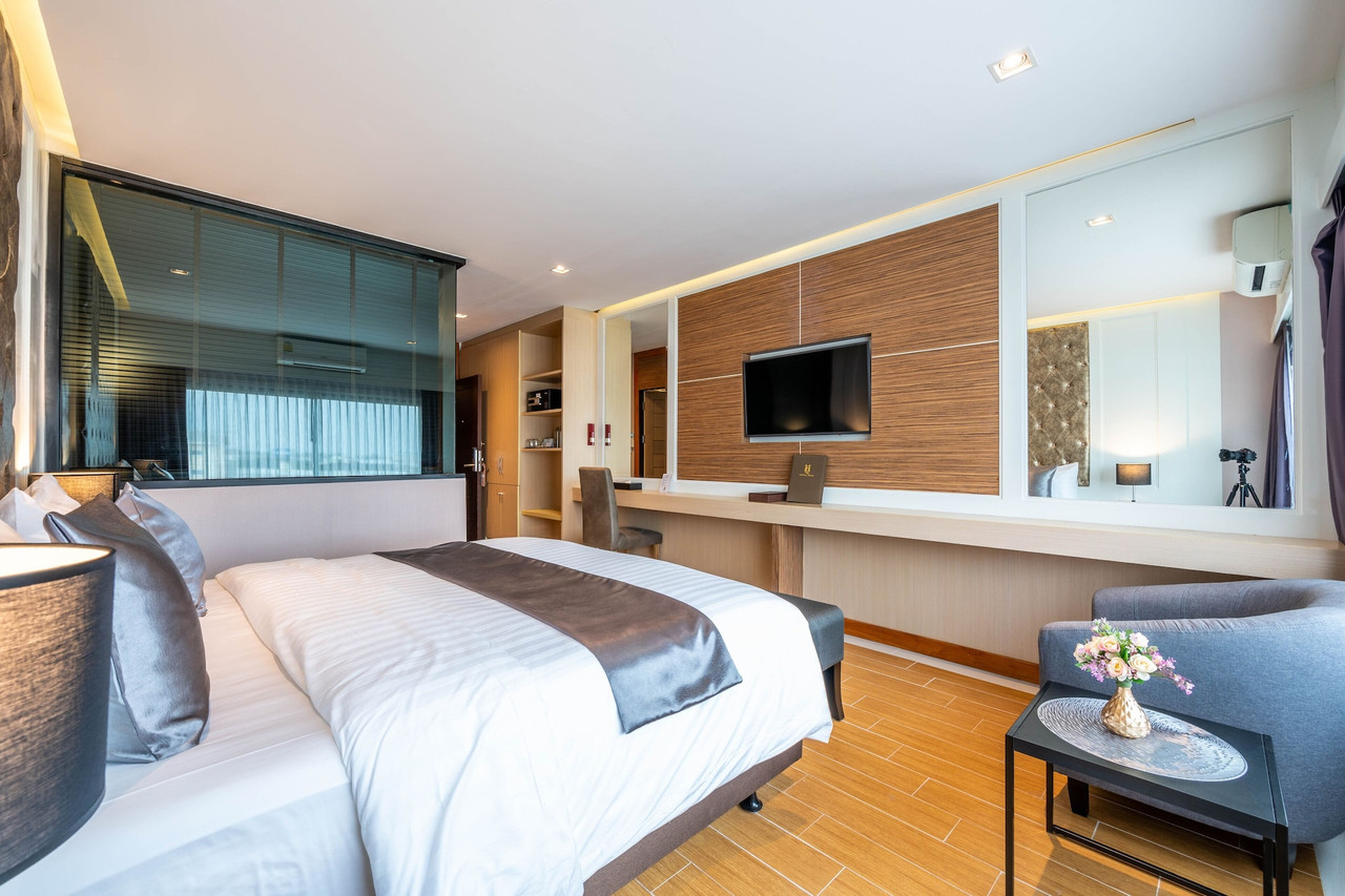 Hotel Muq guest room with king bed, wood feature wall and flat-screen TV