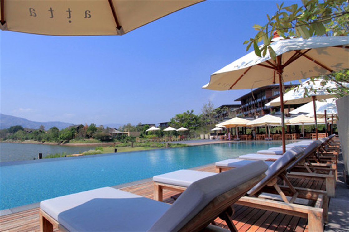Infinity pool reaching into the lake with the hills behind it at atta Lakeside Resort Suite