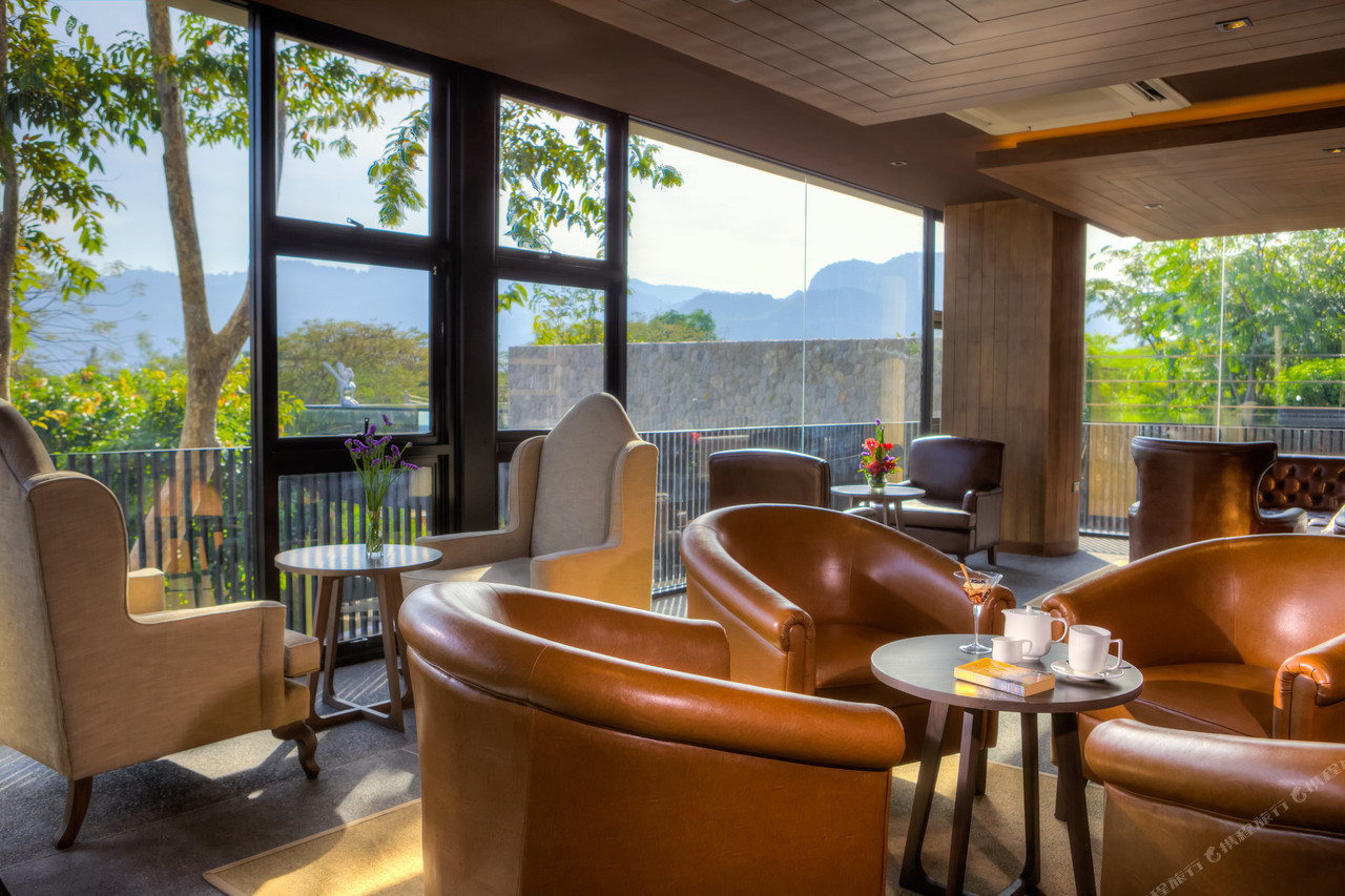 Resort lounge with leather chairs and panoramic glass over the Khao Yai hills