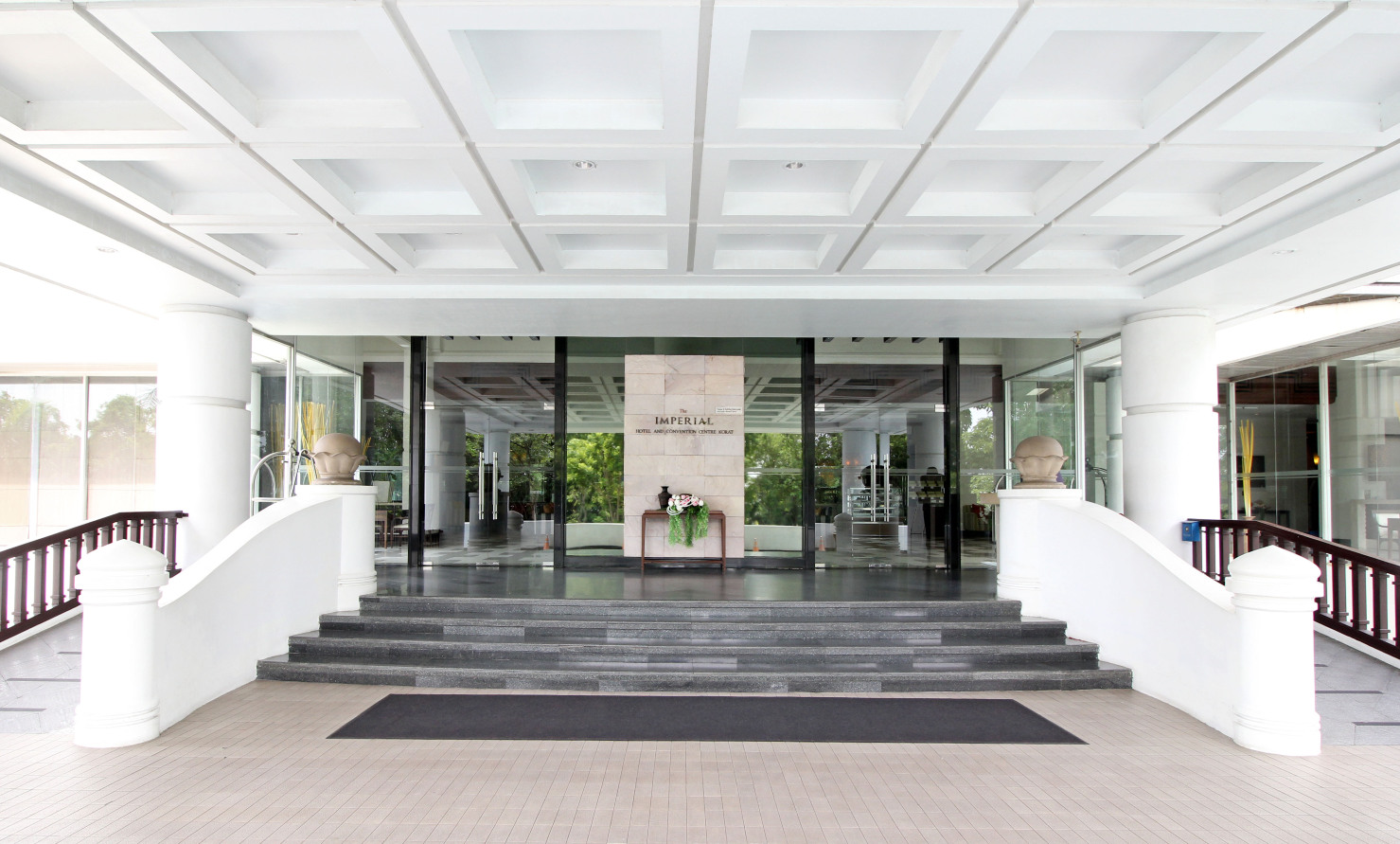 ทางเข้าล็อบบี้ The Imperial Hotel Korat มีป้ายชื่อโรงแรมบนเสาหิน
