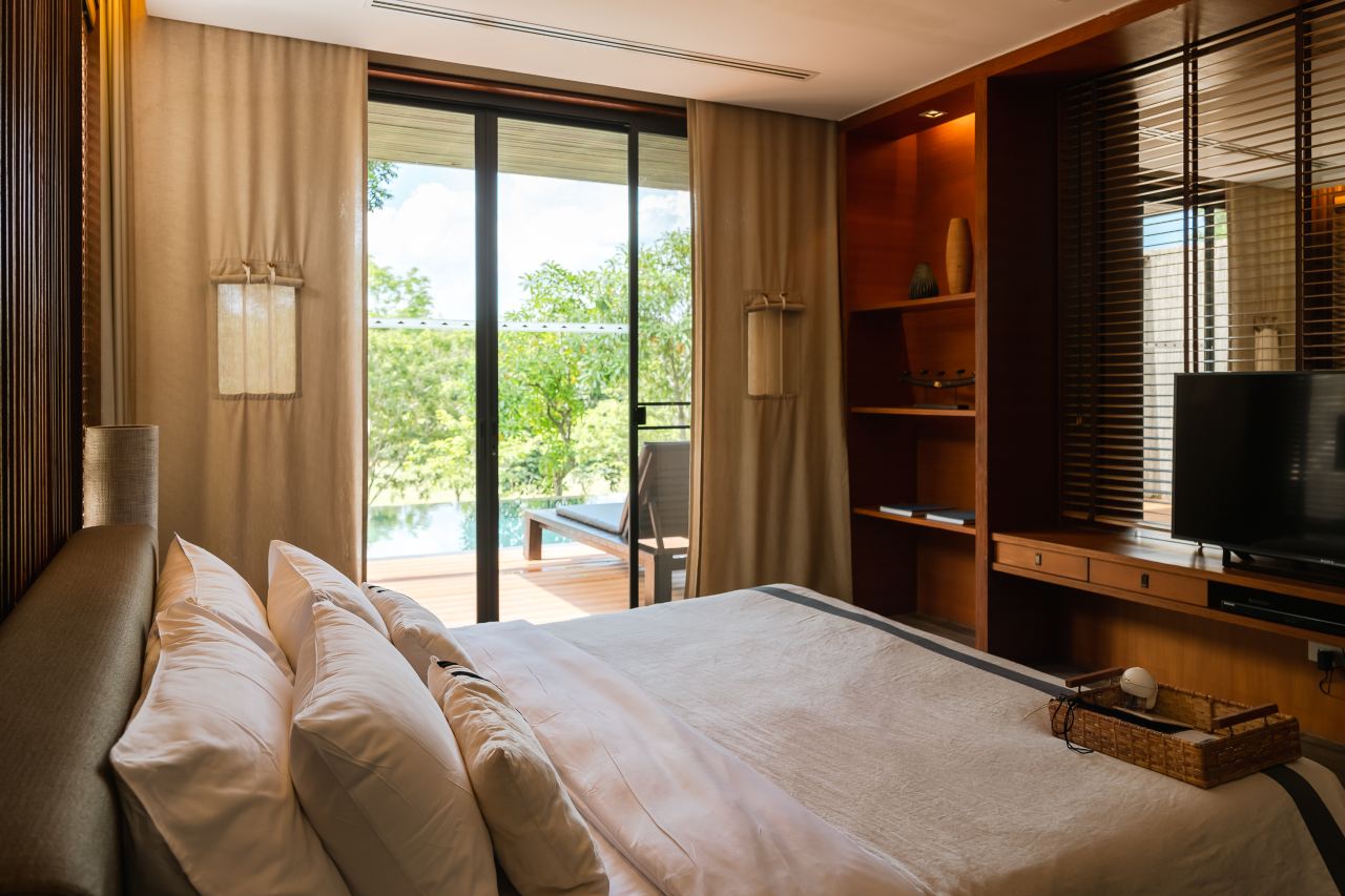 Muthi Maya villa bedroom with full-height glass opening onto its private pool and forest