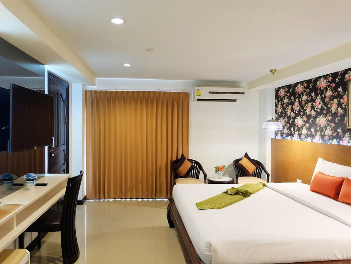 ห้องพักเตียงคู่ ผนังลายดอก โทนไม้ มีโต๊ะทำงาน Grand Hill Resort and Spa