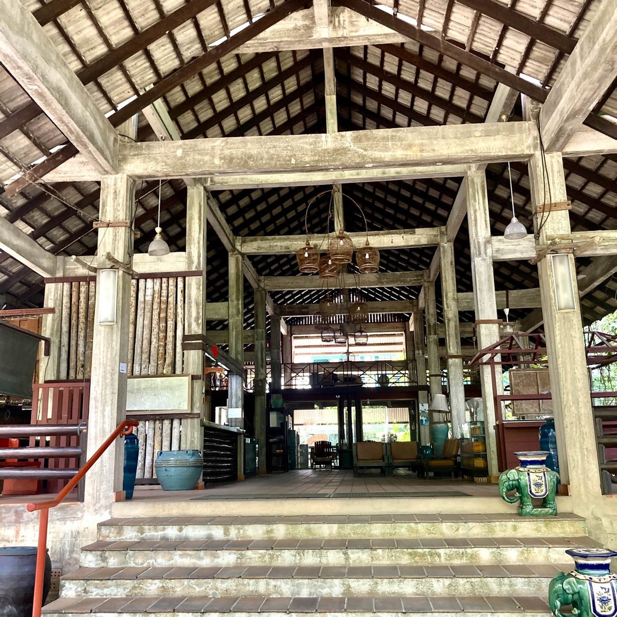 Open high-roofed timber pavilion serving as the lobby and common area at Nakorn Garden Inn