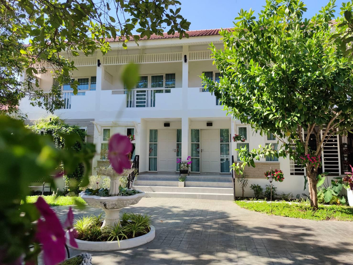 อาคารสีขาวสไตล์ล้านนาและน้ำพุในสวนหน้าโรงแรม