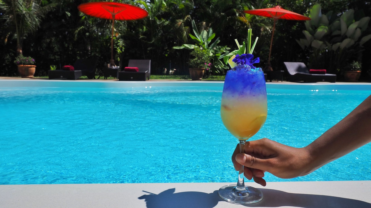 Saltwater swimming pool with red Thai paper parasols at Nan Seasons Boutique Resort