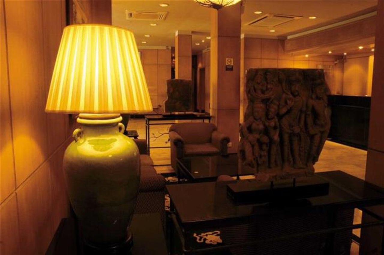 Hotel lobby with a ceramic table lamp and a carved stone relief sculpture