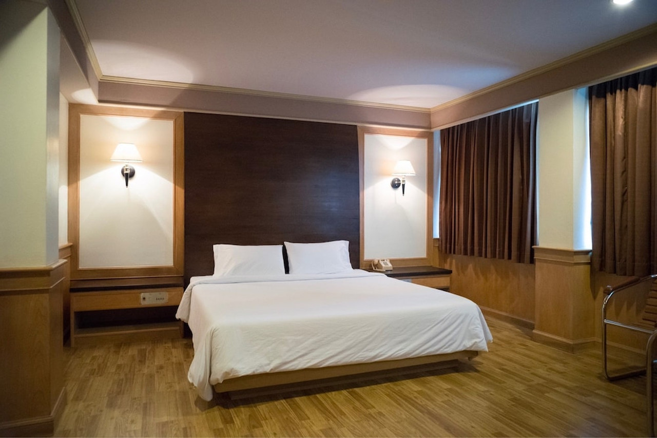 Spacious suite with parquet flooring and a dark-wood feature wall
