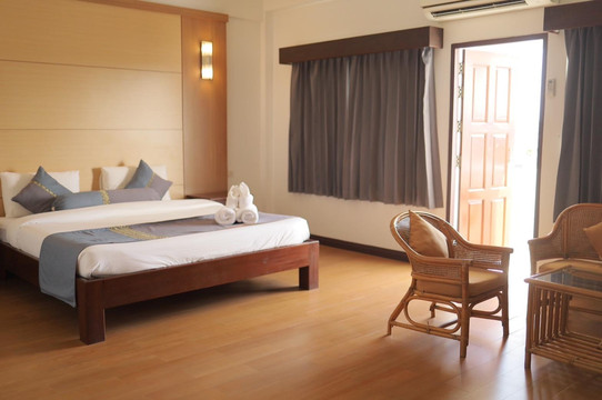 ห้องพักของ The Tanyong Hotel มีพื้นไม้ เตียงคู่ และประตูออกระเบียง