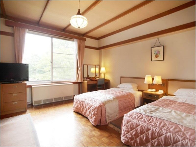 Classic twin room at Nikko Kanaya Hotel — parquet floors, period pendant lamp and garden view