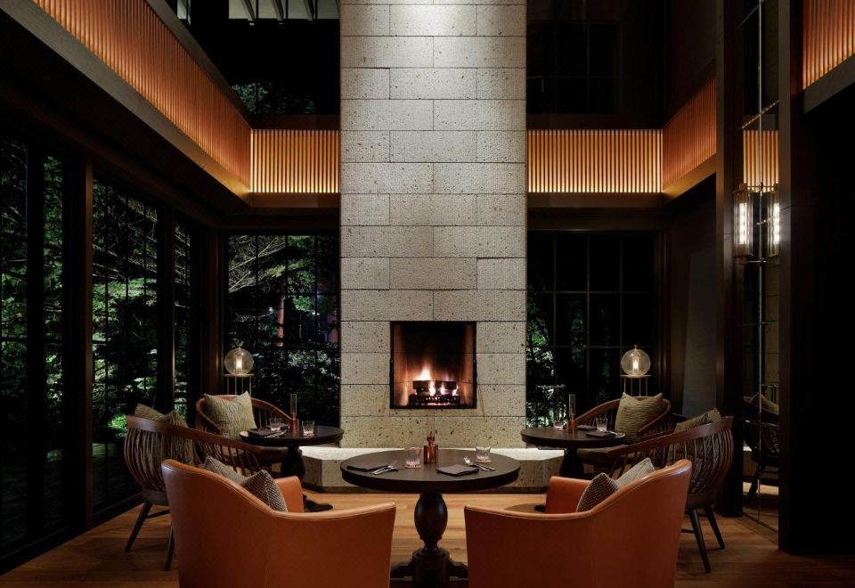 The Lobby Lounge fireplace at The Ritz-Carlton Nikko at night with forest views
