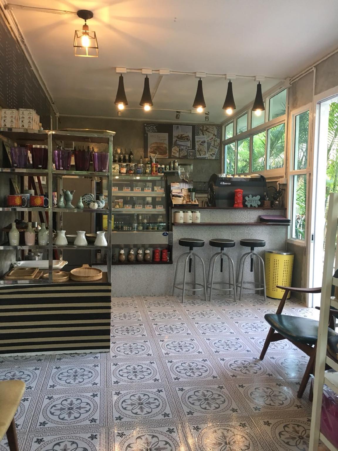 On-site café with patterned encaustic-tile floor, an espresso machine and vintage shelving