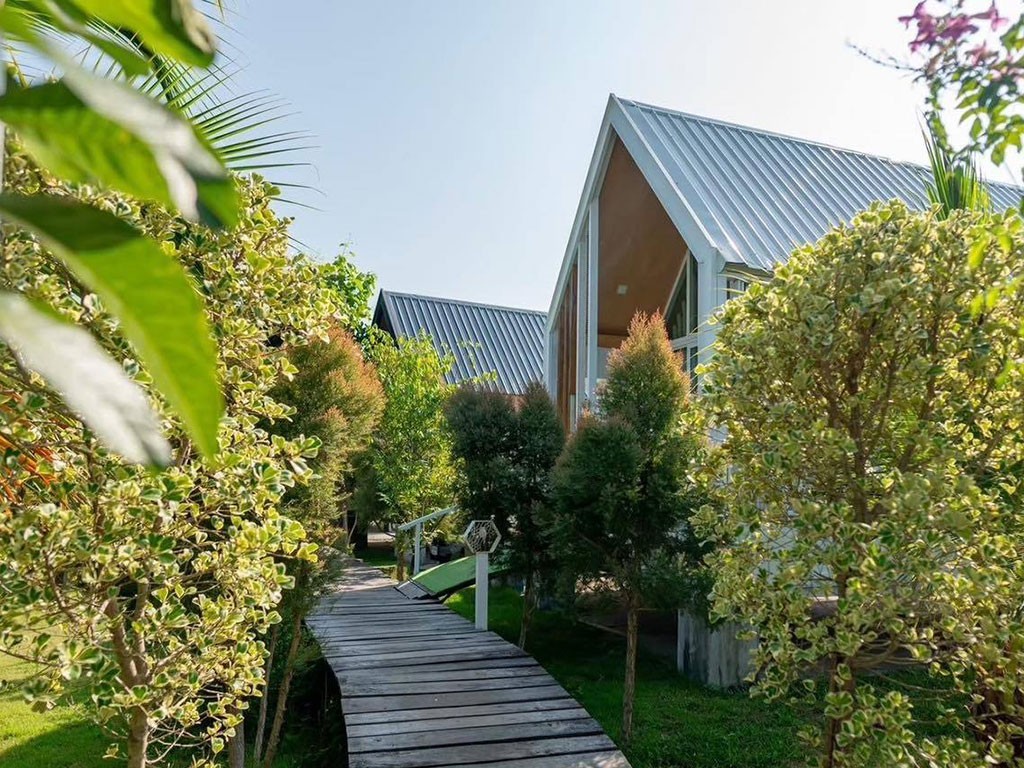 วิลล่าหลังคาจั่วทรง A-frame ของ Nordic House & Coffee กับทางเดินไม้ผ่านสวน