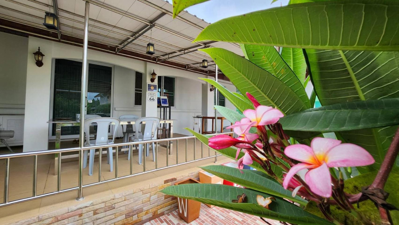 Covered garden terrace with frangipani flowers at the guest house