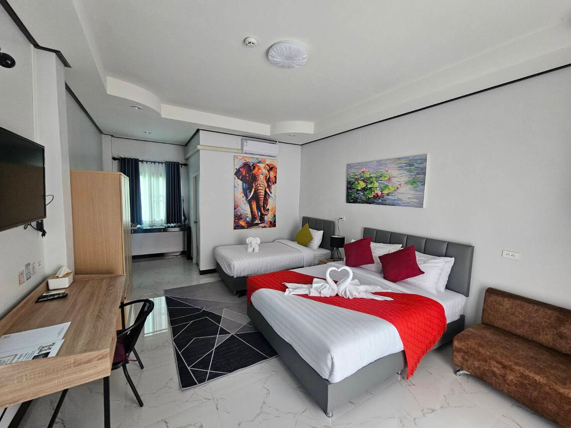 Modern room with a king and a twin bed, red runner, marble floor and elephant artwork