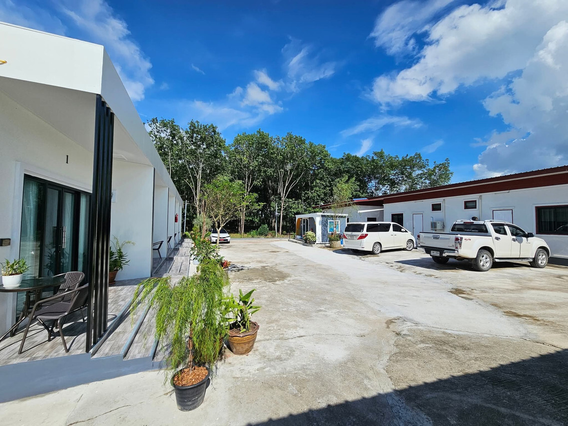 Front courtyard with balcony seating, free on-site parking and surrounding trees