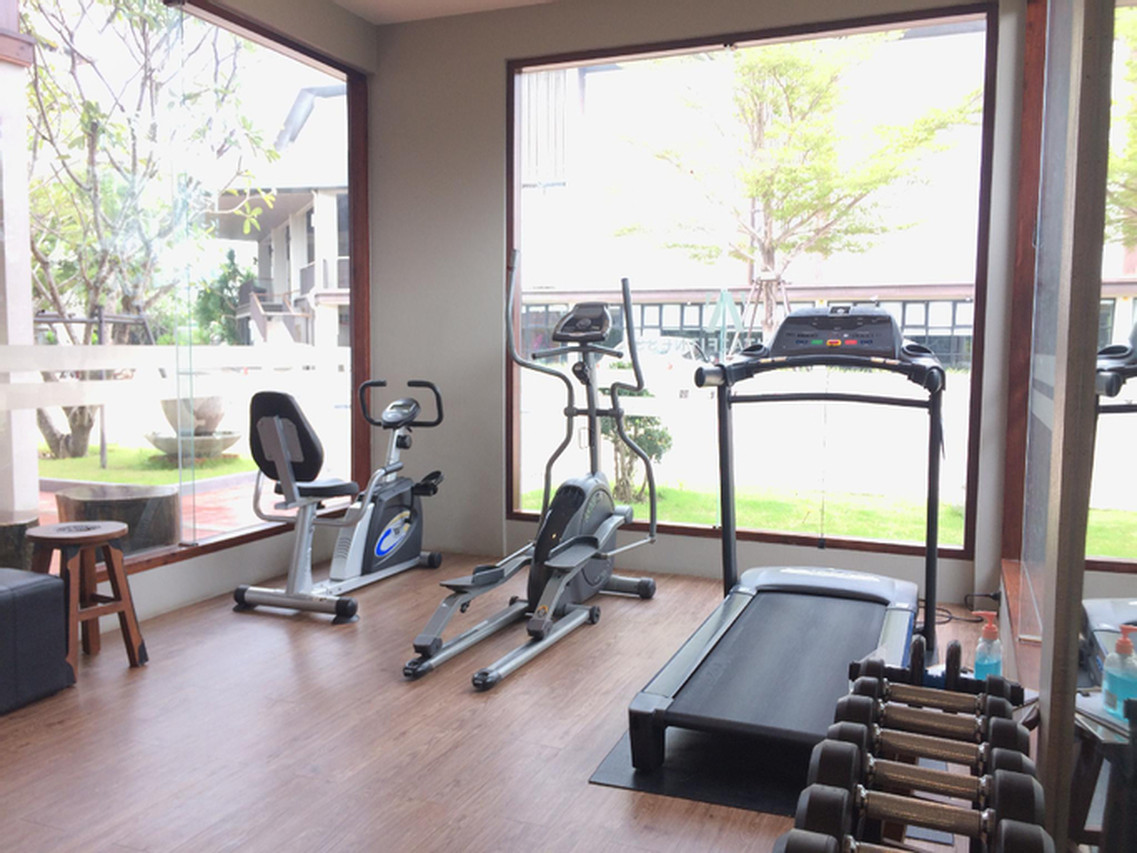 Glass-walled fitness room looking onto the garden at Amanta Hotel Nongkhai