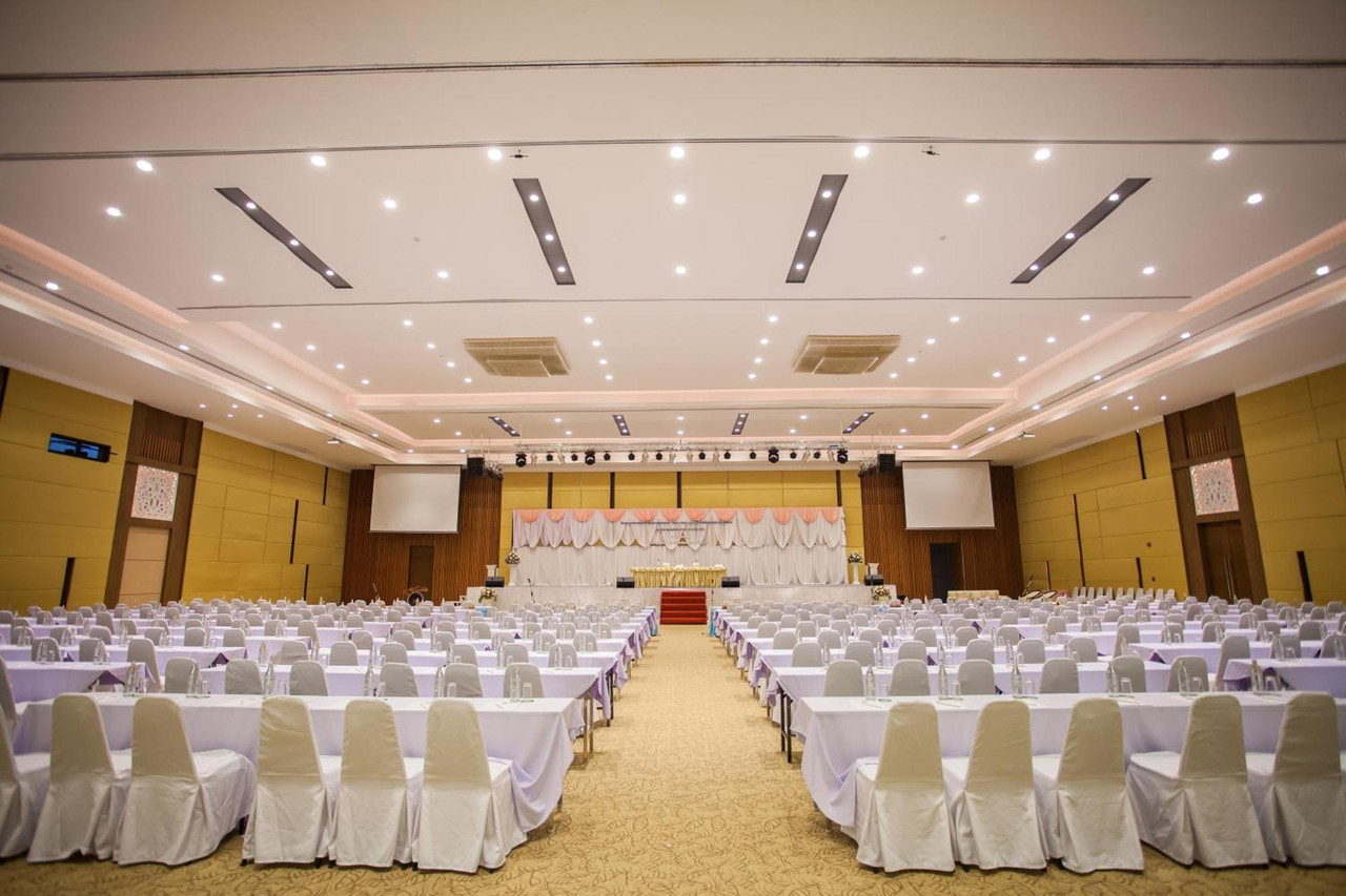 Large convention and banquet hall set up seminar-style with white-covered chairs