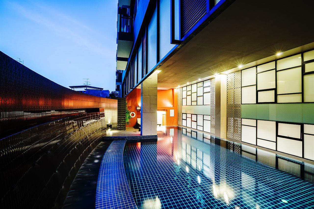 Indoor swimming pool with blue mosaic tiling and an illuminated glass-block wall