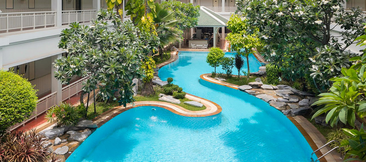 สระว่ายน้ำทรงโค้งกลางสวนเขตร้อนของ Buddy Oriental Riverside Pakkred