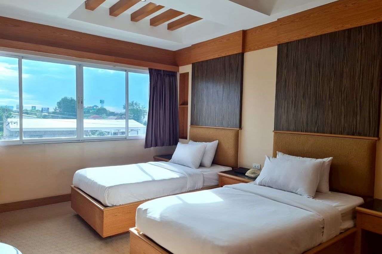 Standard Twin room at The Rich Hotel with a wide window over the Nonthaburi neighbourhood
