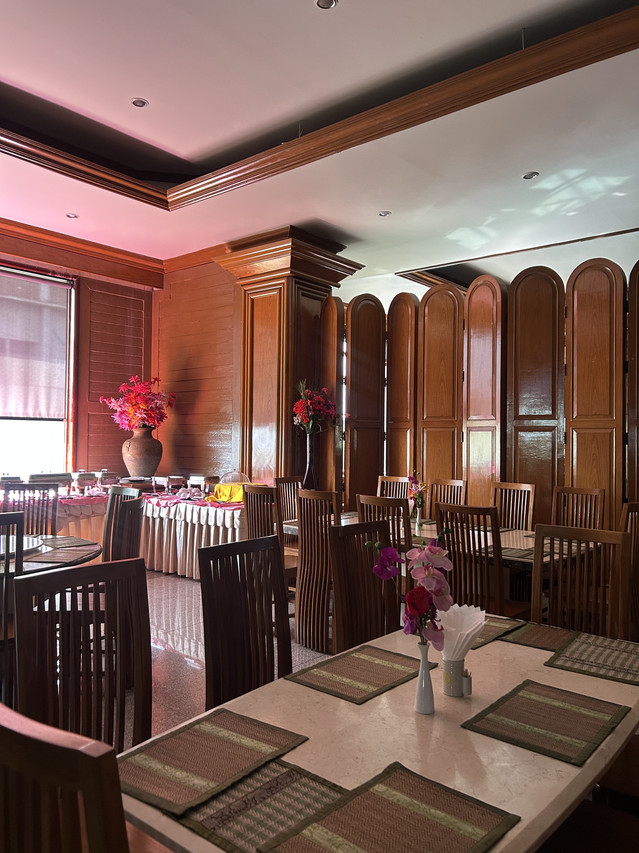 On-site Thai restaurant with wood-panelled walls and set tables
