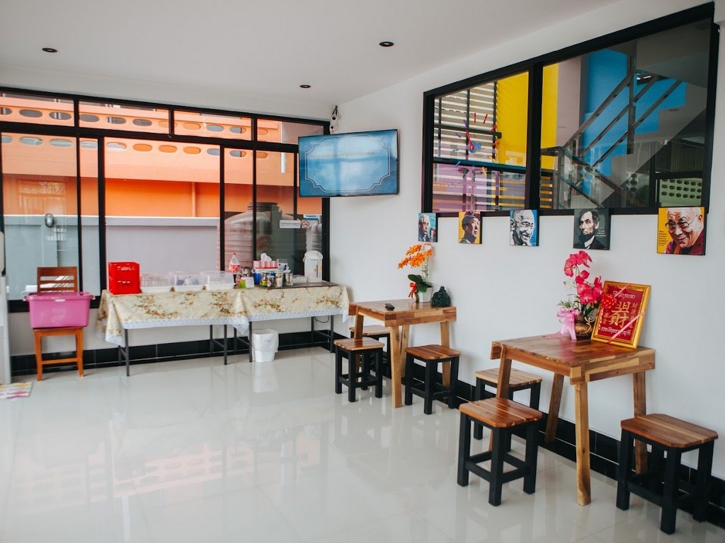 มุมนั่งเล่นและอาหารเช้าส่วนกลาง โต๊ะไม้ ทีวี ของ Chokphaiboon Apartment Pattani