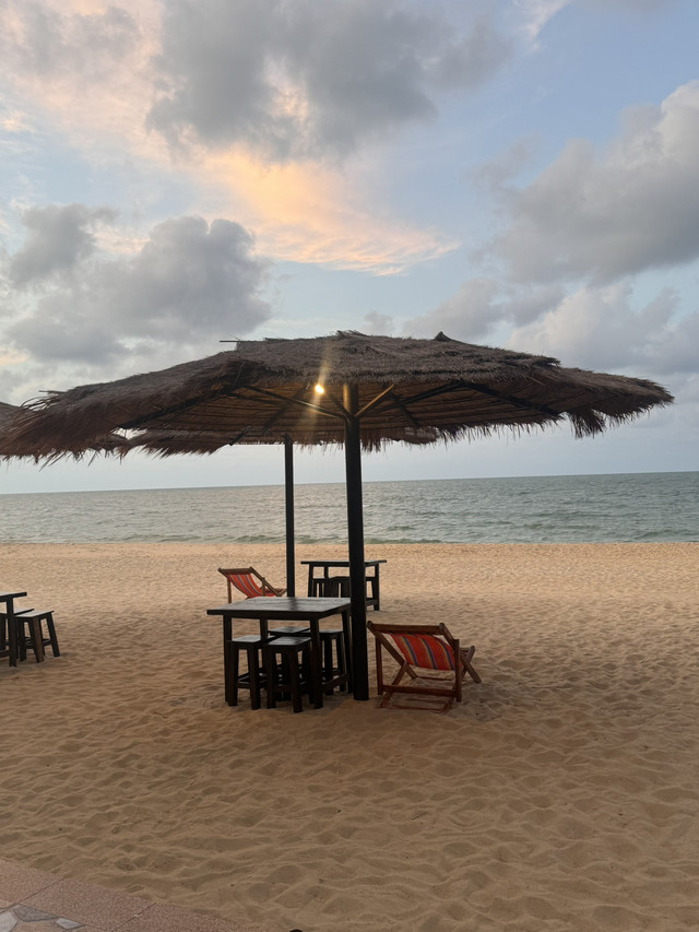 Thatched umbrella and deck chairs on Talo Kapo Beach at sunset