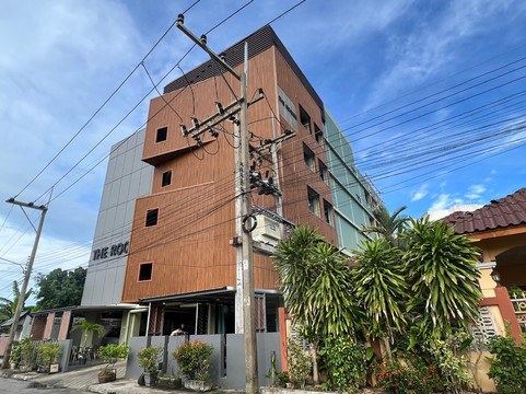 The Rooms Residence tower from the street, brown wood-slatted facade