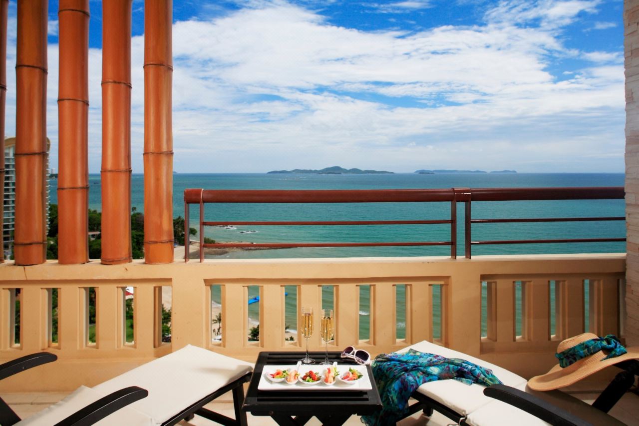 Ocean-facing room balcony with sun loungers and island views