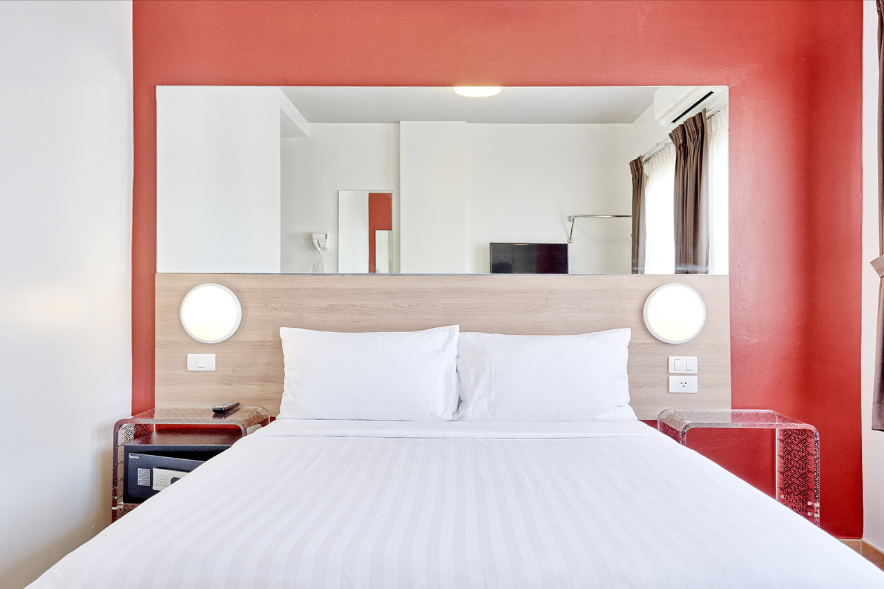Superior room with double bed and red feature wall at Easy Planet Pattaya