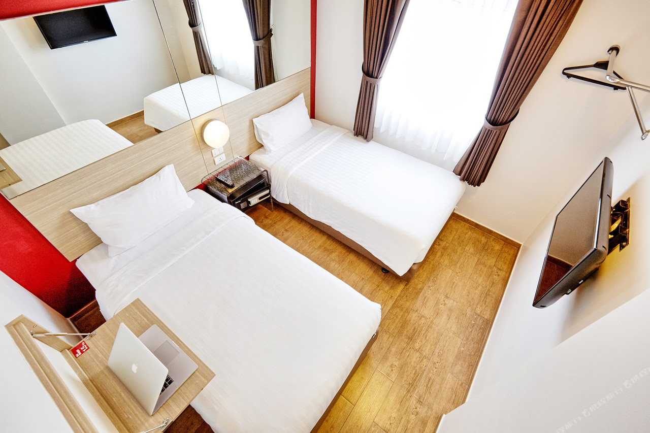 Standard twin room with wood floor and minimal, functional furnishing