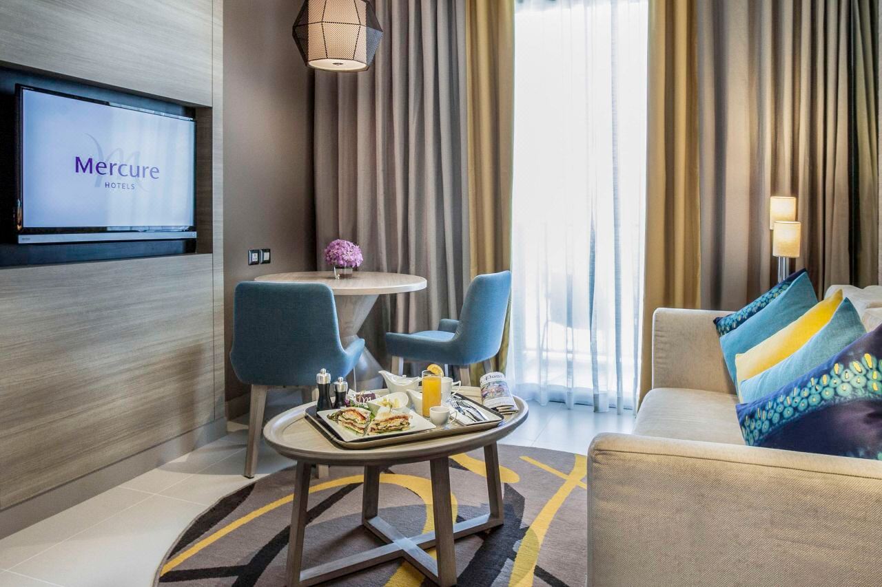 Contemporary Mercure guest room with sofa and private balcony