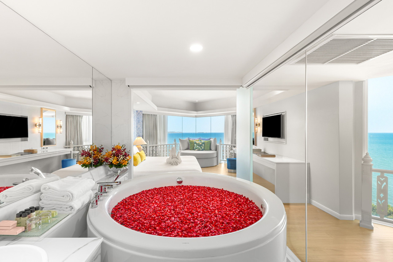 Sea-view suite with a round tub and floor-to-ceiling windows over Pattaya Bay