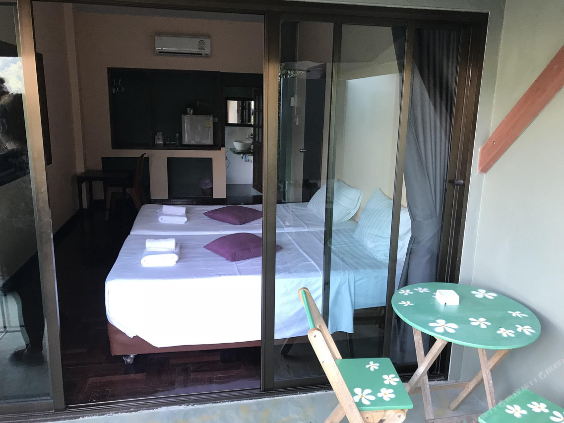 ห้องพักพร้อมระเบียงส่วนตัว ตู้เย็น และโต๊ะเล็กที่ Home Phang Nga Guesthouse