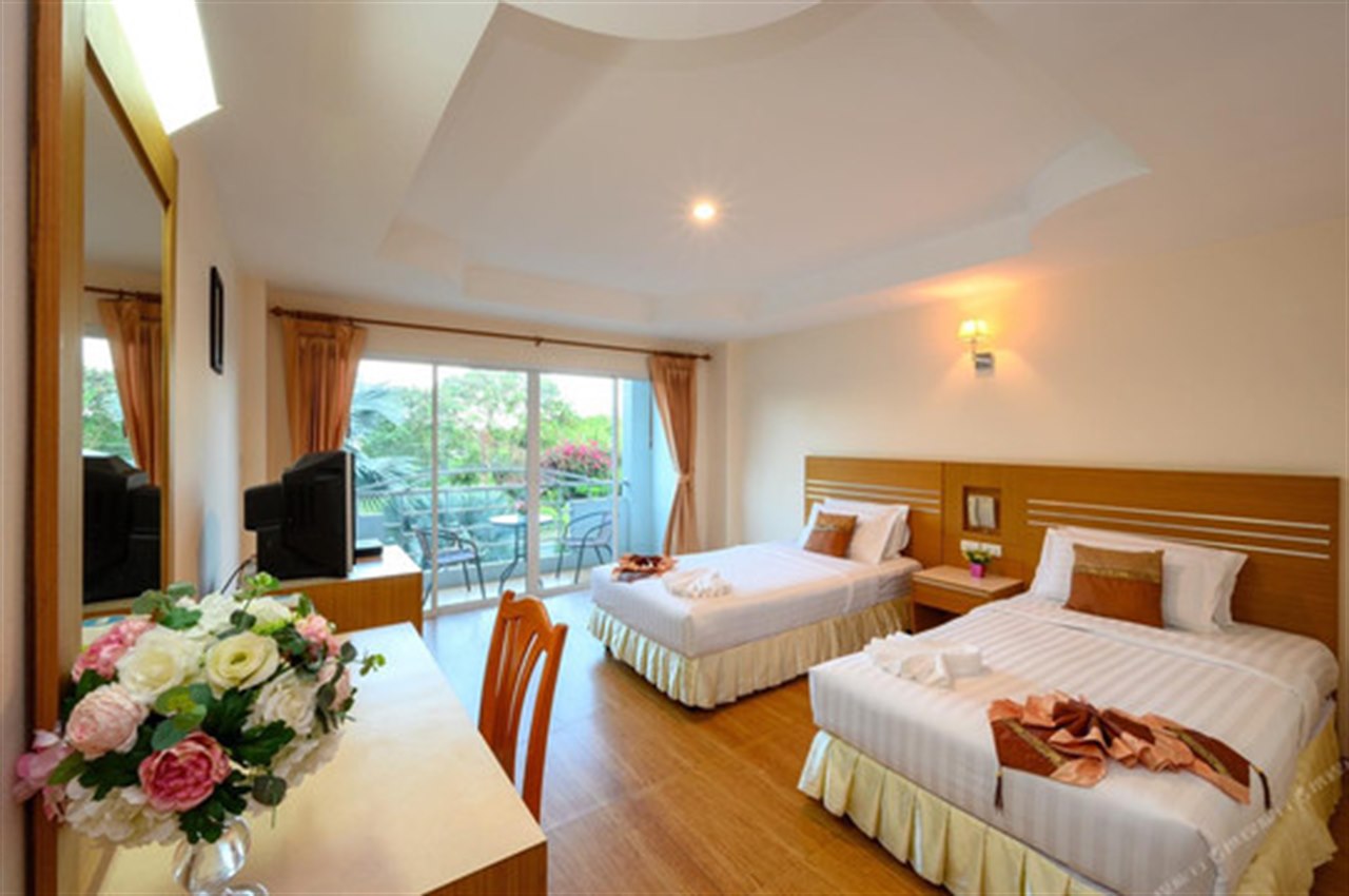 Twin room at Chaikana Thani Hotel with a balcony and wood floor