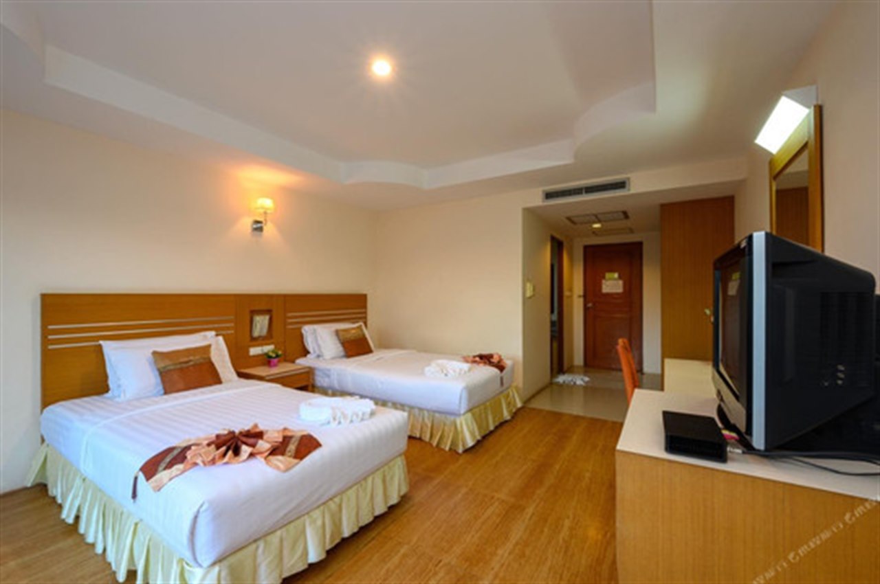 Room with a double and a single bed in warm tones
