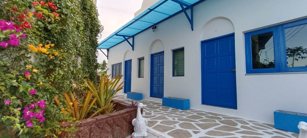 Blue-and-white Santorini-style rooms with arched doors and bougainvillea at Phatthalung Meridian Hotel
