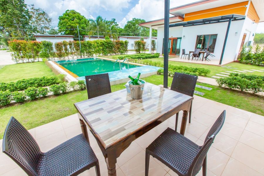 Garden swimming pool with poolside dining table at Ozone Resort Khao Chaison