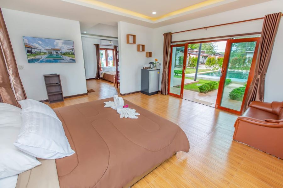 Pool-view room with glass doors opening onto the garden and pool