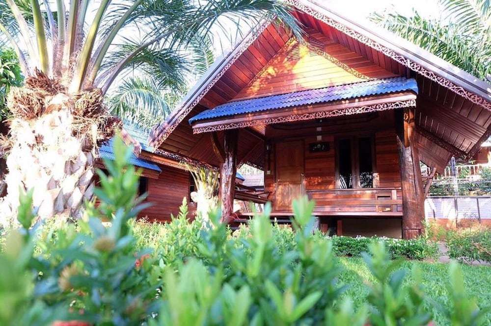 เรือนไม้สักหลังเดี่ยวหลังคากระเบื้องน้ำเงินกลางสวนที่ Roithong Resort