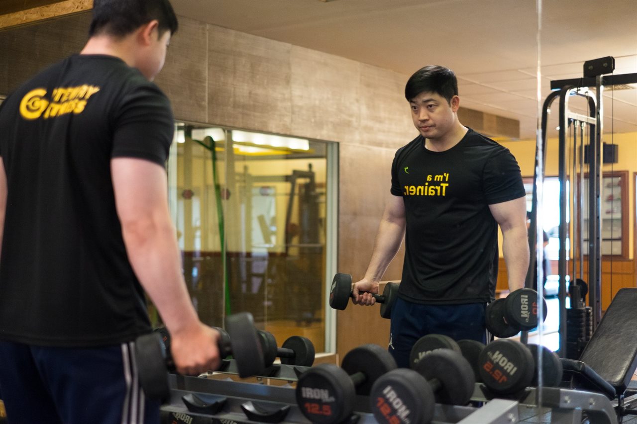ห้องฟิตเนส Gateway Fitness ของโรงแรมพร้อมดัมเบลและเทรนเนอร์ใส่เสื้อโลโก้โรงแรม