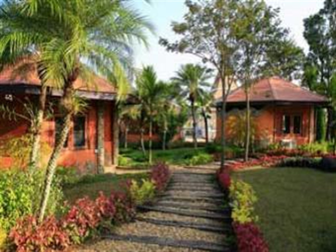 Terracotta-roofed standalone cottages with a stone garden path at Khao Kho Highland Resort
