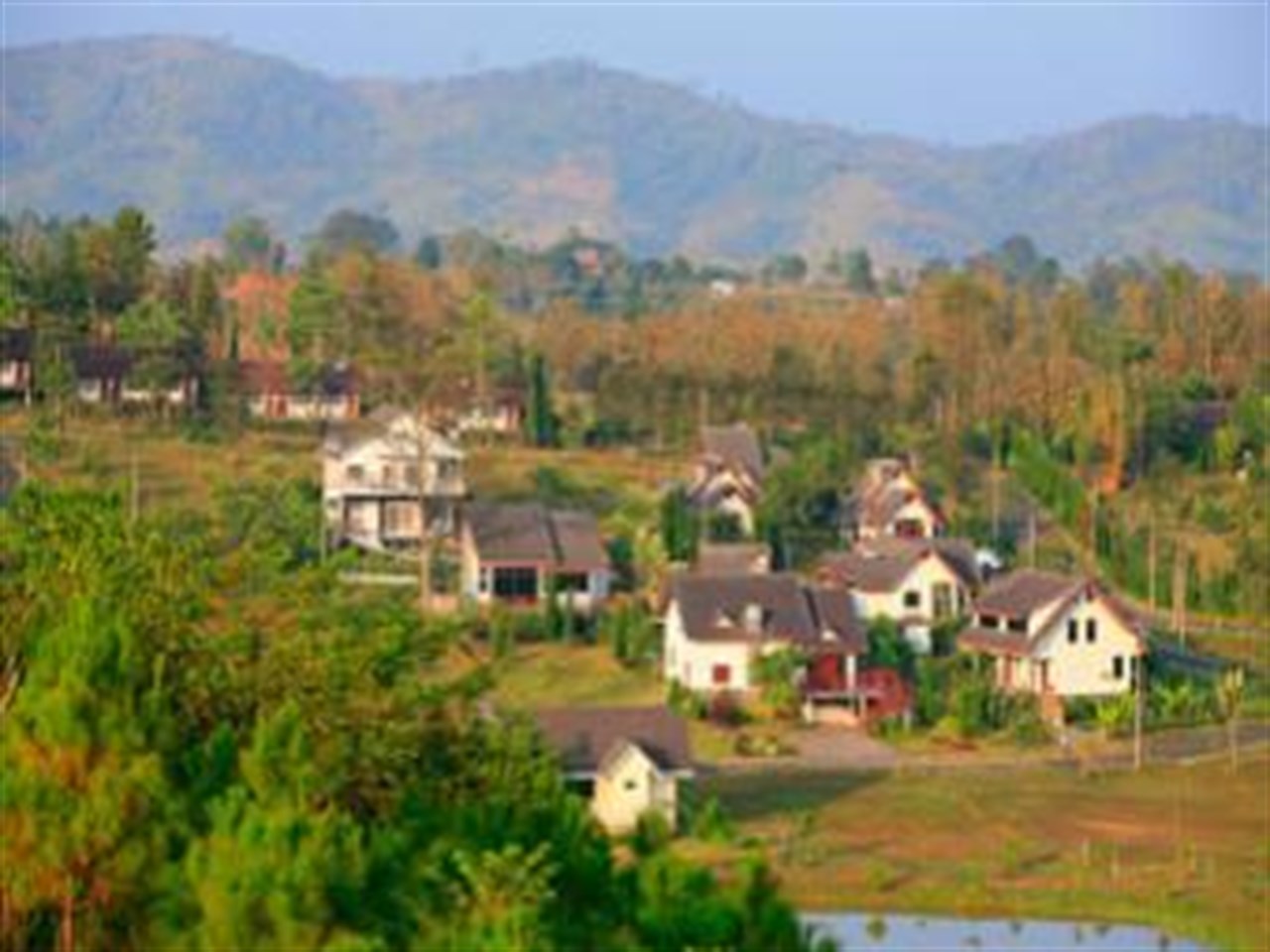 Cottages spread across a hillside with a mountain backdrop on Khao Kho