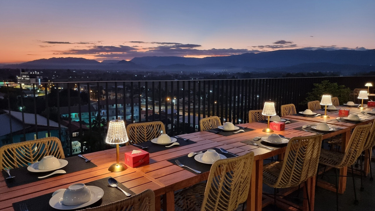 Rooftop dining table at Livist Resort Phetchabun overlooking the mountains and town lights at sunset