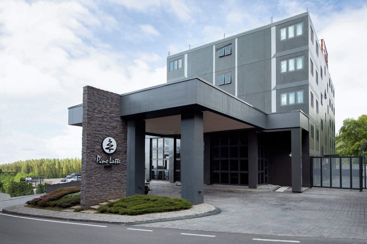 Pino Latte Khao Kho hotel building with the pine-tree logo sign at the entrance
